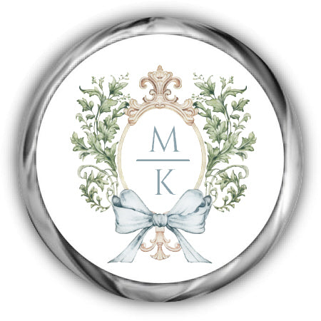 Decorative emblem with initials 'MK' and a bow, framed by foliage on a white background.
